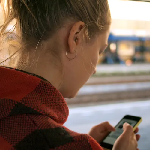 woman looking at phone, practicing sexting examples